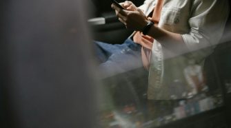 Pessoa distante olhando o celular, representando os problemas dos relacionamentos modernos