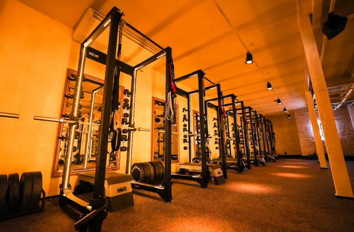 stúdio do Tonus Gym com iluminação vermelha característica e equipamentos para musculação funcional e integrada. Onde usar o cupom Tonus.
