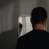 Homem olhando seu reflexo no espelho, ilustrando a transição de mentalidade e a mudança de comportamento na relação com o próprio corpo.