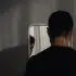 Homem olhando seu reflexo no espelho, ilustrando a transição de mentalidade e a mudança de comportamento na relação com o próprio corpo.